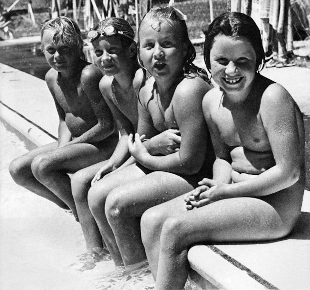 Kids sittin on the side of a pool